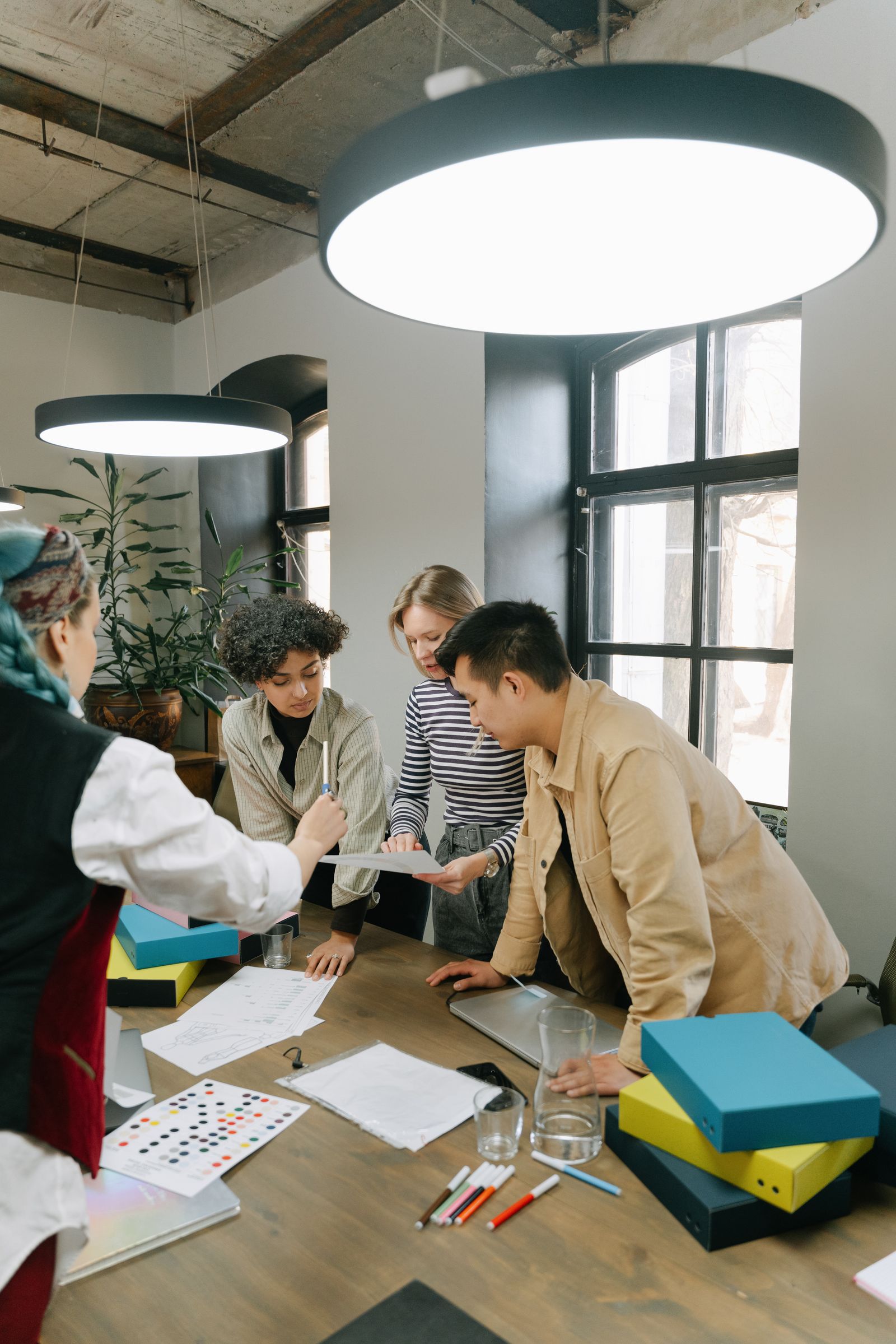 Diverse team of colleagues working around a laptop in a bright open office.