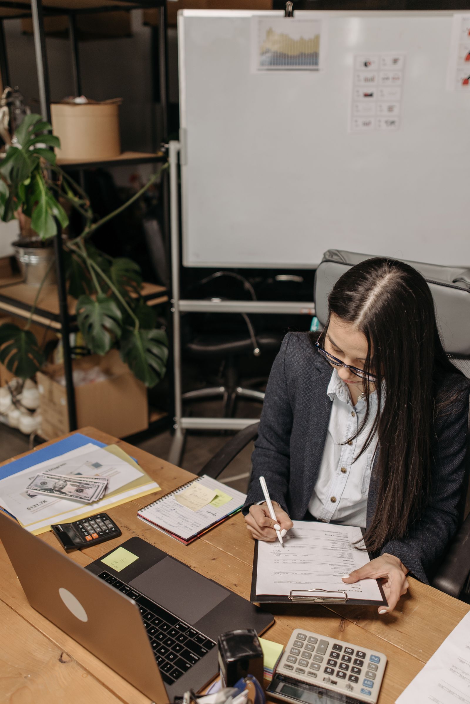 Bookkeeper reviewing accounting records and receipts at a desk.