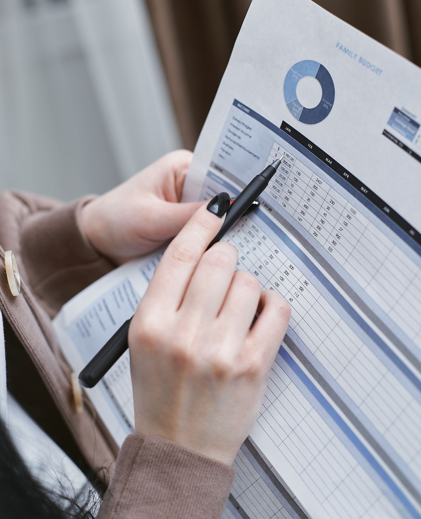 Financial planning spreadsheet on a desk with calculator and pen.