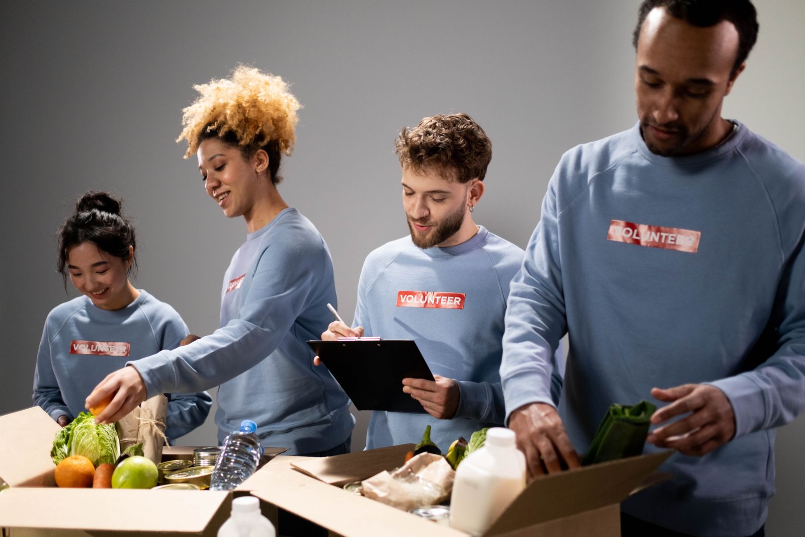 Food-bank volunteers sorting fresh produce and boxes for distribution.