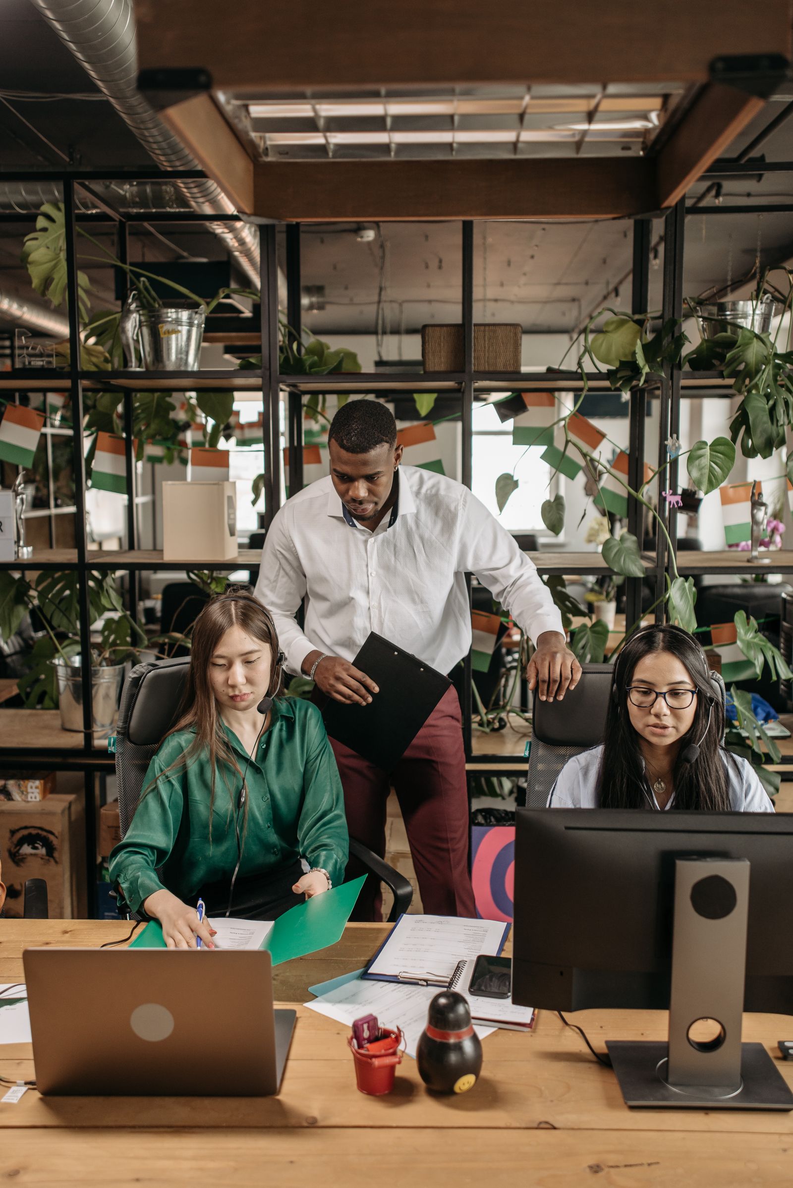Diverse professional team meeting around a laptop in an open collaborative space.