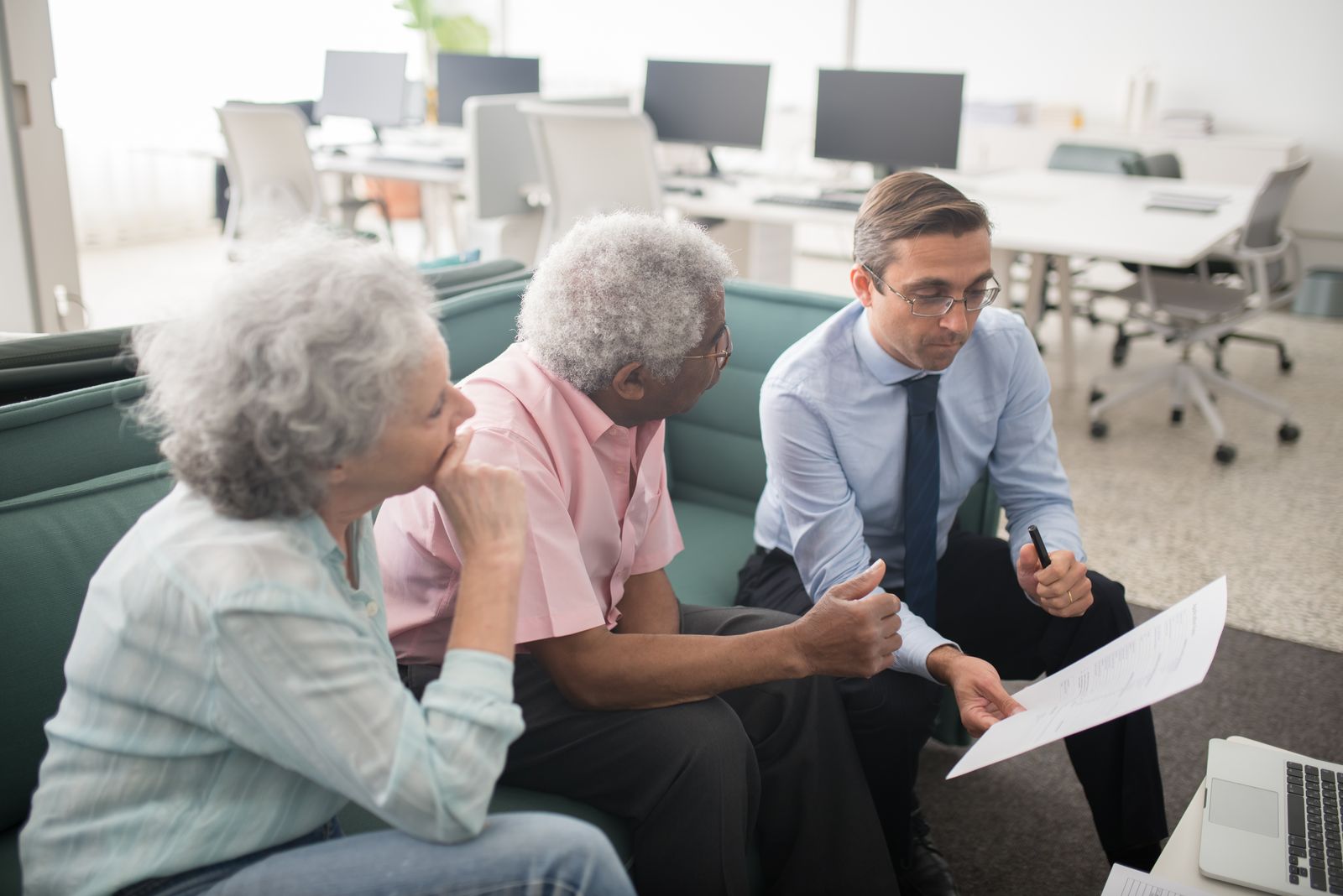 Advisor and executive reviewing financial planning documents together at a bright table.